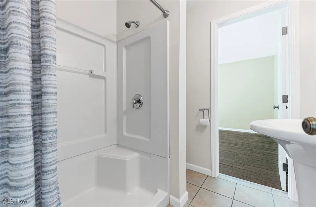 Full bath with a stall shower and light tile patterned floors