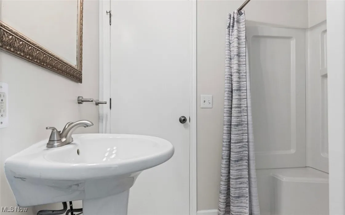 Full bathroom featuring a stall shower and a sink