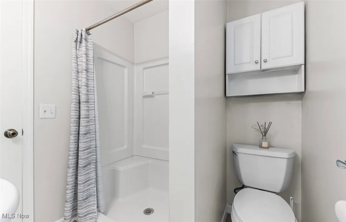 Bathroom with a stall shower and a textured ceiling