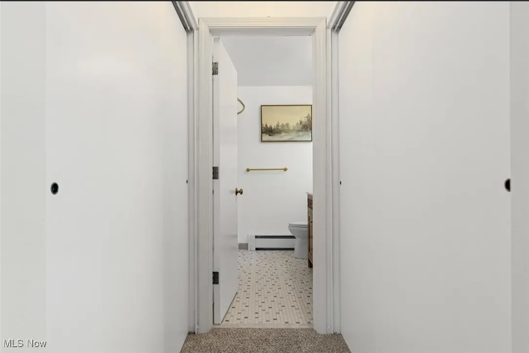 Corridor featuring a baseboard heating unit