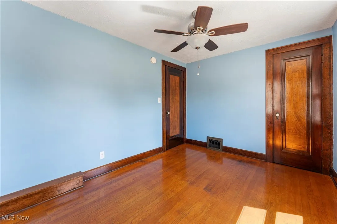 Spare room with hardwood / wood-style floors and ceiling fan