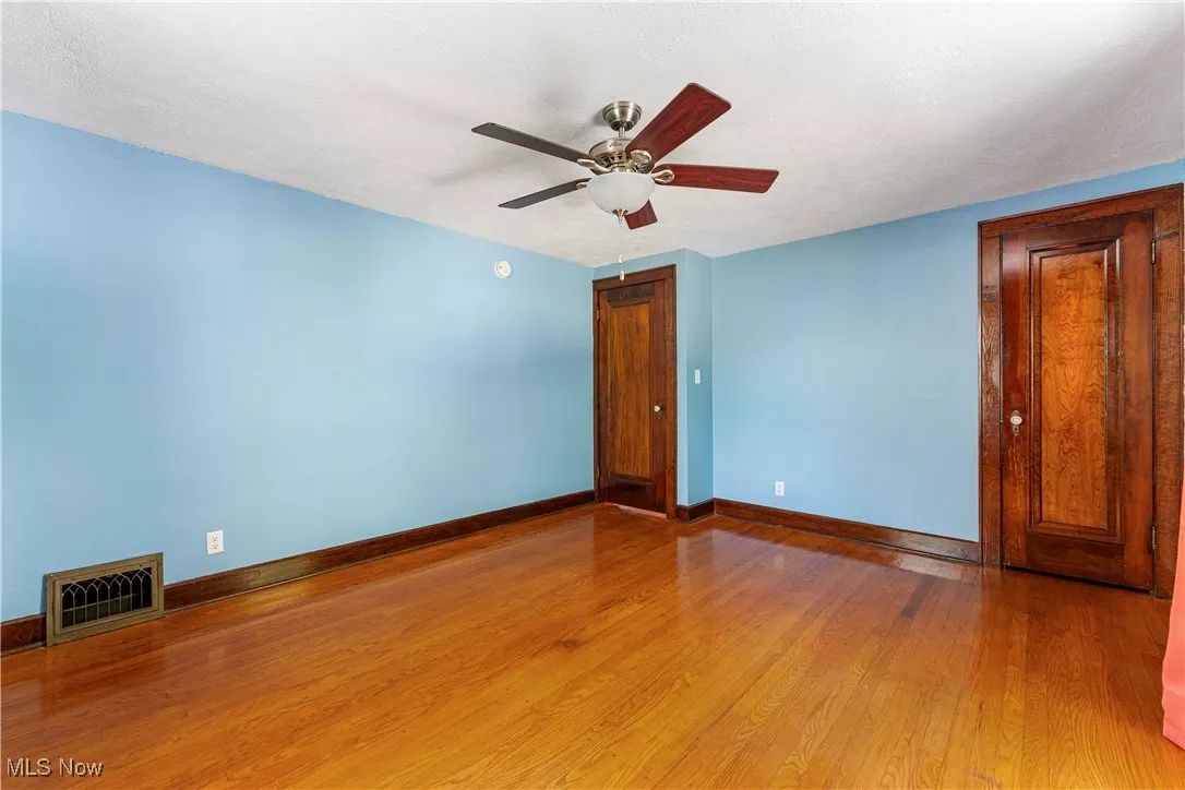 Unfurnished room with wood finished floors, a textured ceiling, and ceiling fan