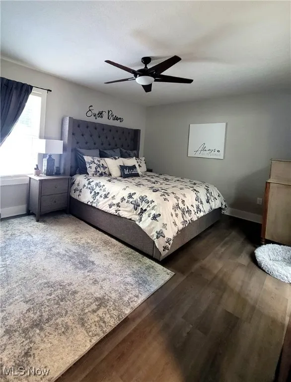 Bedroom with ceiling fan and dark wood-style floors
