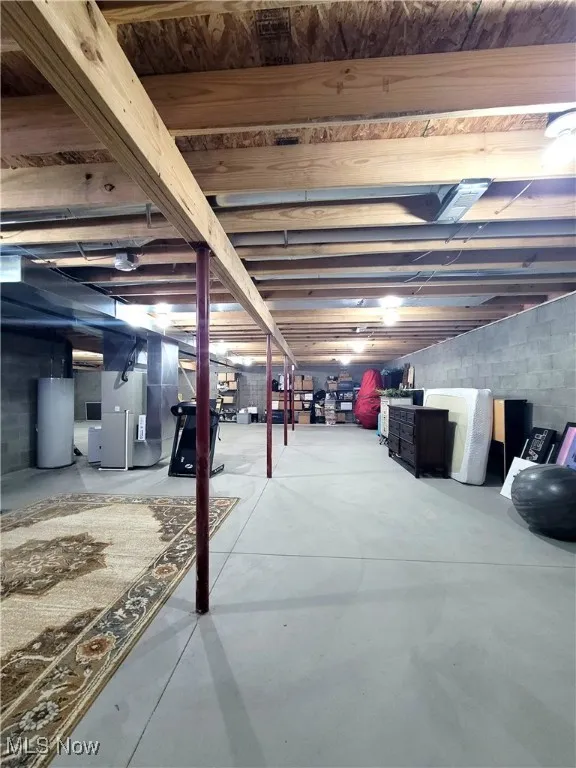 Unfinished basement featuring water heater and heating unit