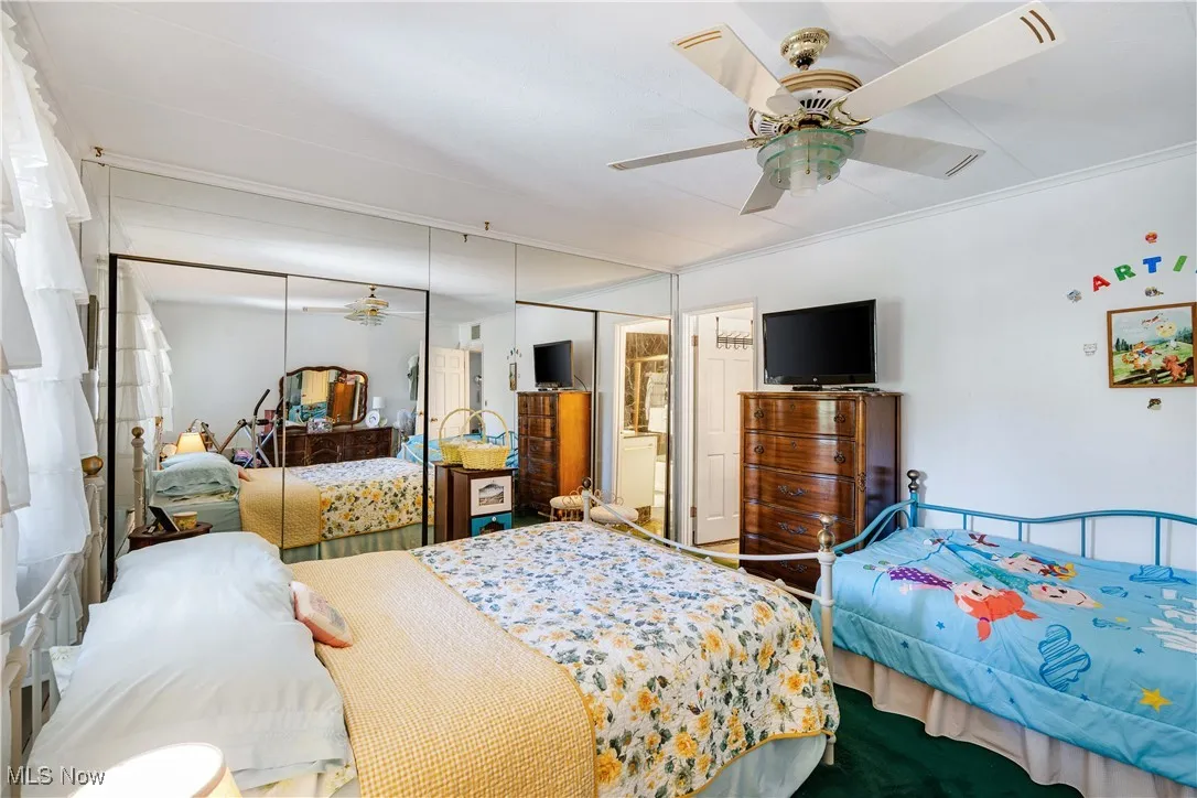Bedroom with a closet, a ceiling fan, and crown molding