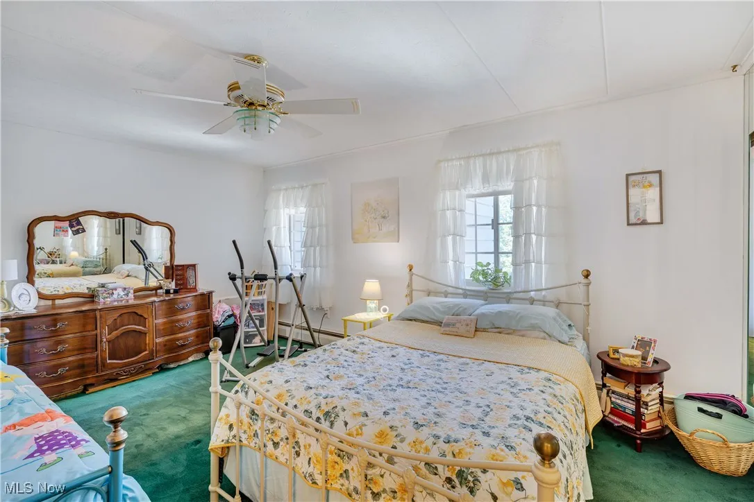 Bedroom featuring carpet, ceiling fan, and a baseboard radiator
