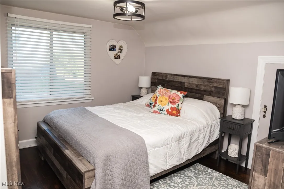 Bedroom with lofted ceiling and wood finished floors