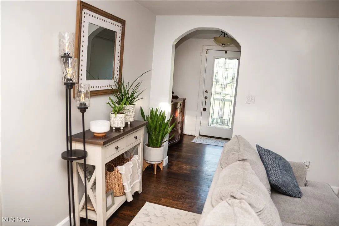 Entryway featuring arched walkways and dark wood finished floors