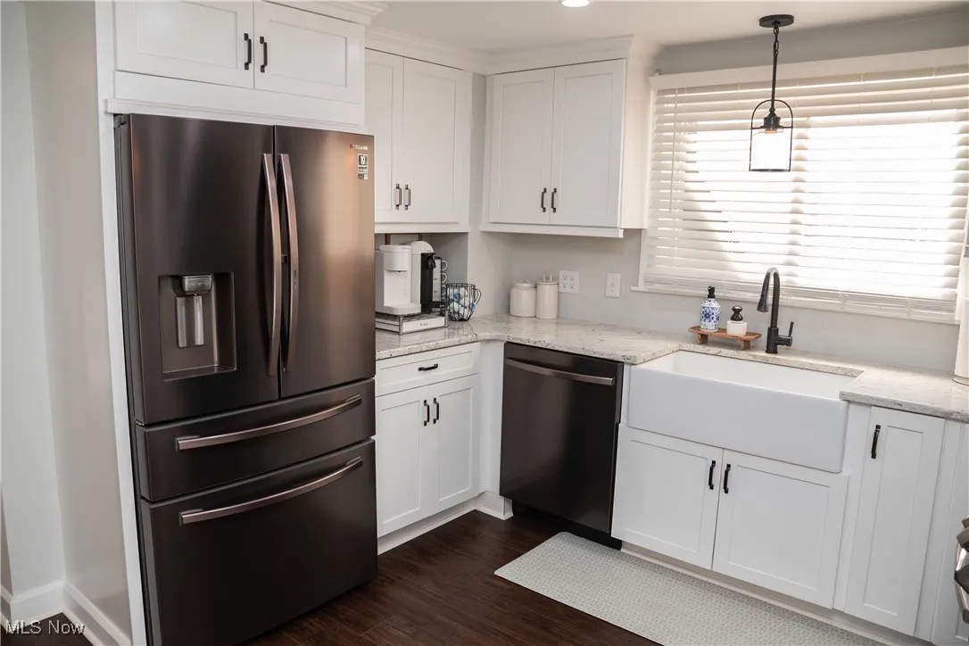 Kitchen featuring stainless steel fridge, light stone counters, white cabinetry, pendant lighting, and recessed lighting