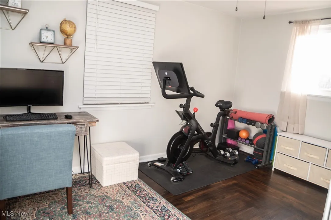 Bedroom featuring dark wood-style floors and baseboards