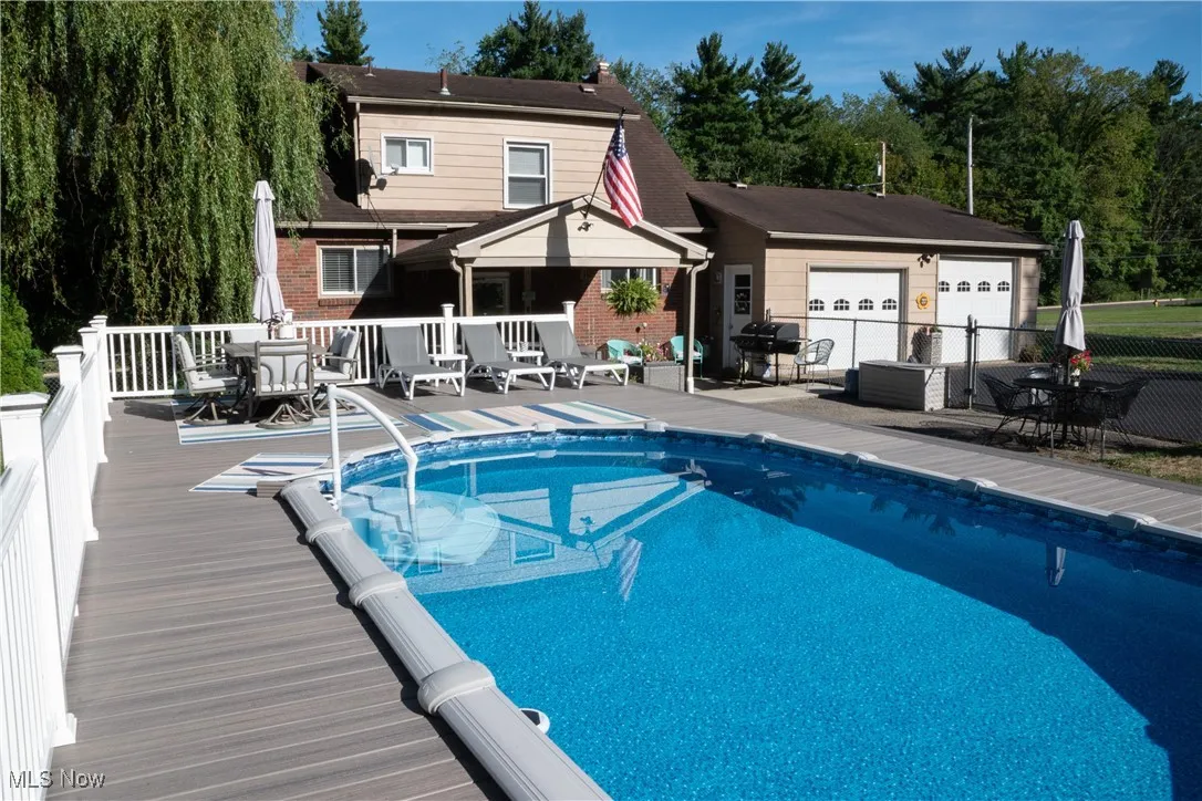 Swimming pool featuring outdoor dining area, a deck, and grilling area
