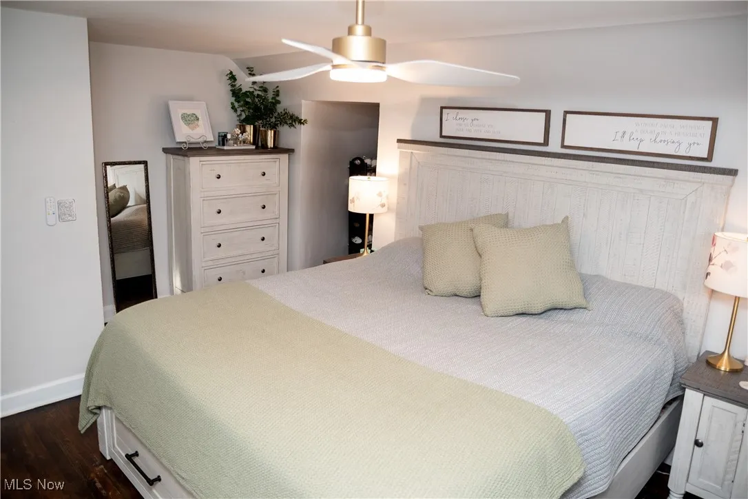 Bedroom with dark wood finished floors and a ceiling fan