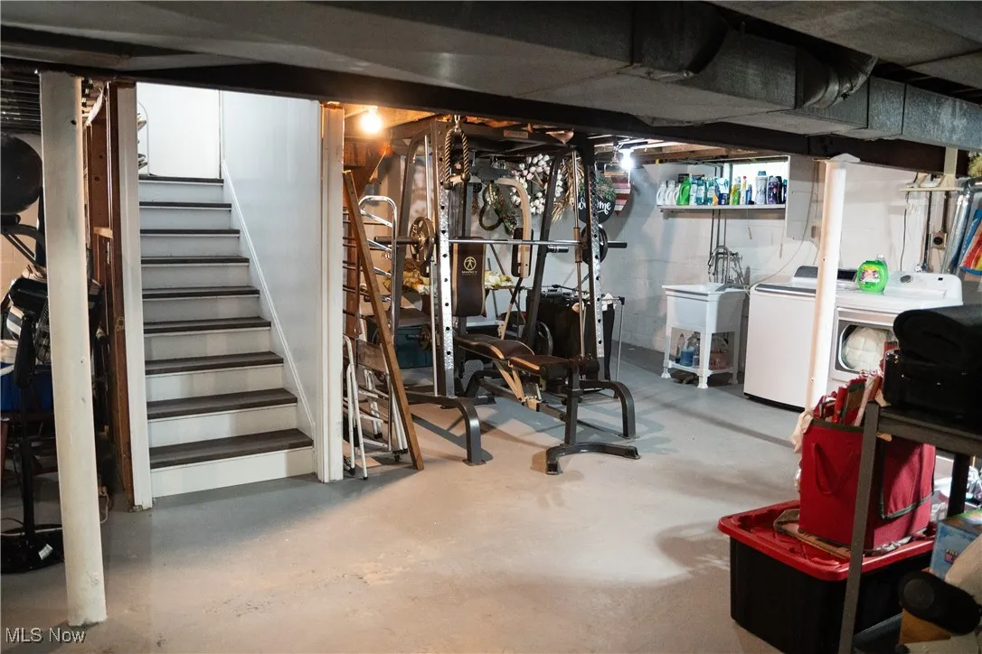 Unfinished basement with washer and clothes dryer and stairs