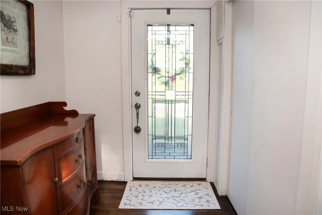 Doorway with wood finished floors and baseboards