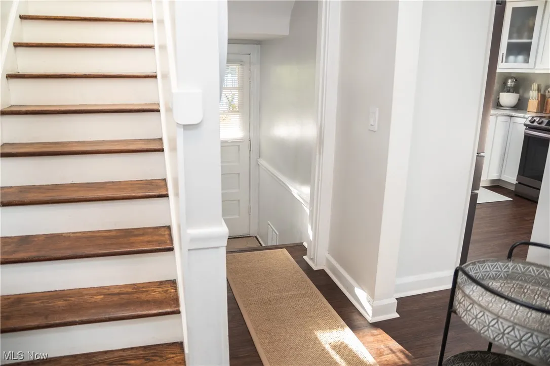Stairs with wood finished floors and baseboards