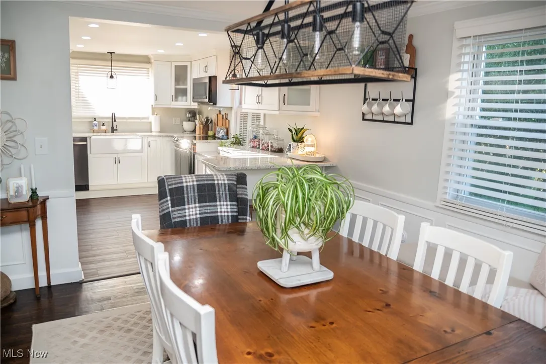 Dining area featuring ornamental molding, anddark LVT floors.