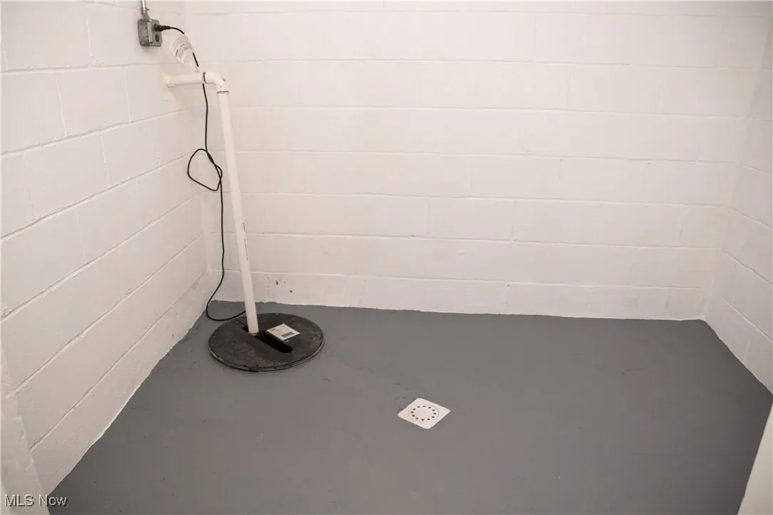 Detailed view of concrete block wall, finished concrete floors, and drainage system
