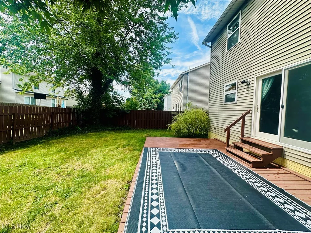 Fenced backyard featuring a deck and entry steps