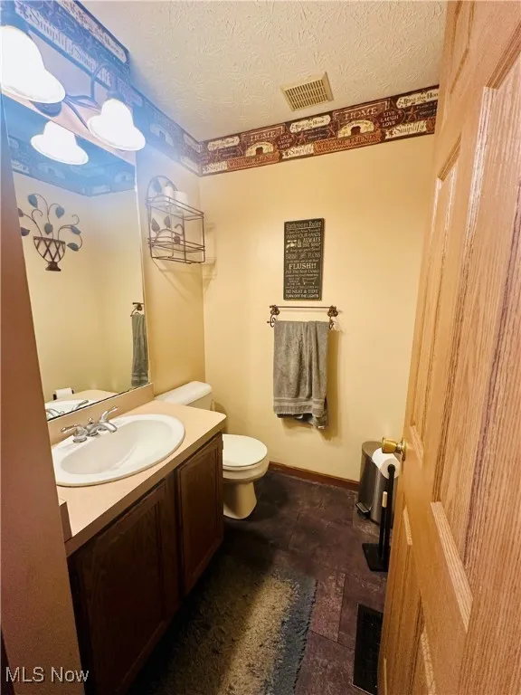 Half bath featuring vanity and a textured ceiling