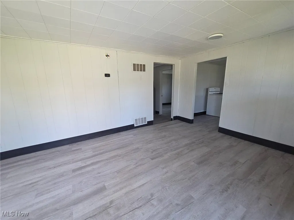 Unfurnished room with wood finished floors and wood walls