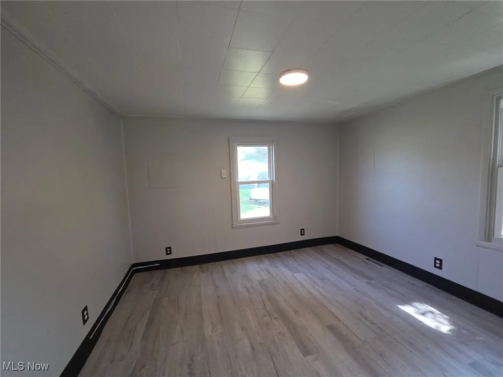 Empty room featuring light wood-style flooring and baseboards