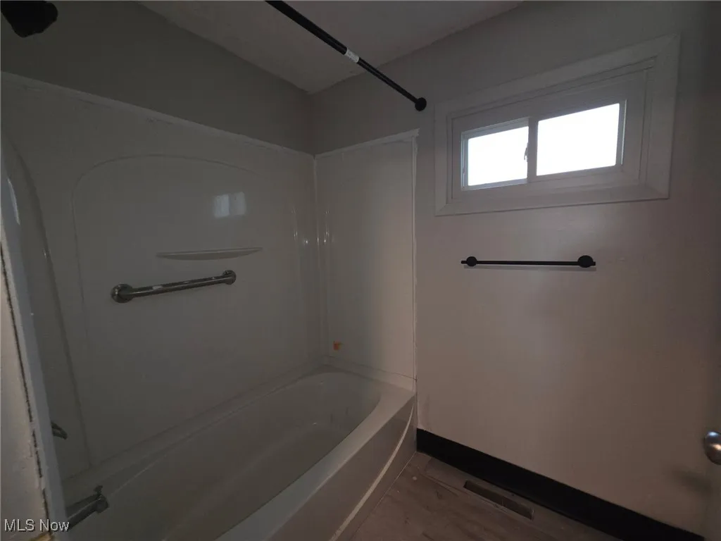 Full bathroom featuring shower / bath combination and light wood-style floors