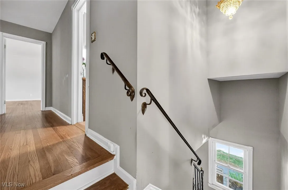 Stairway featuring baseboards and wood finished floors