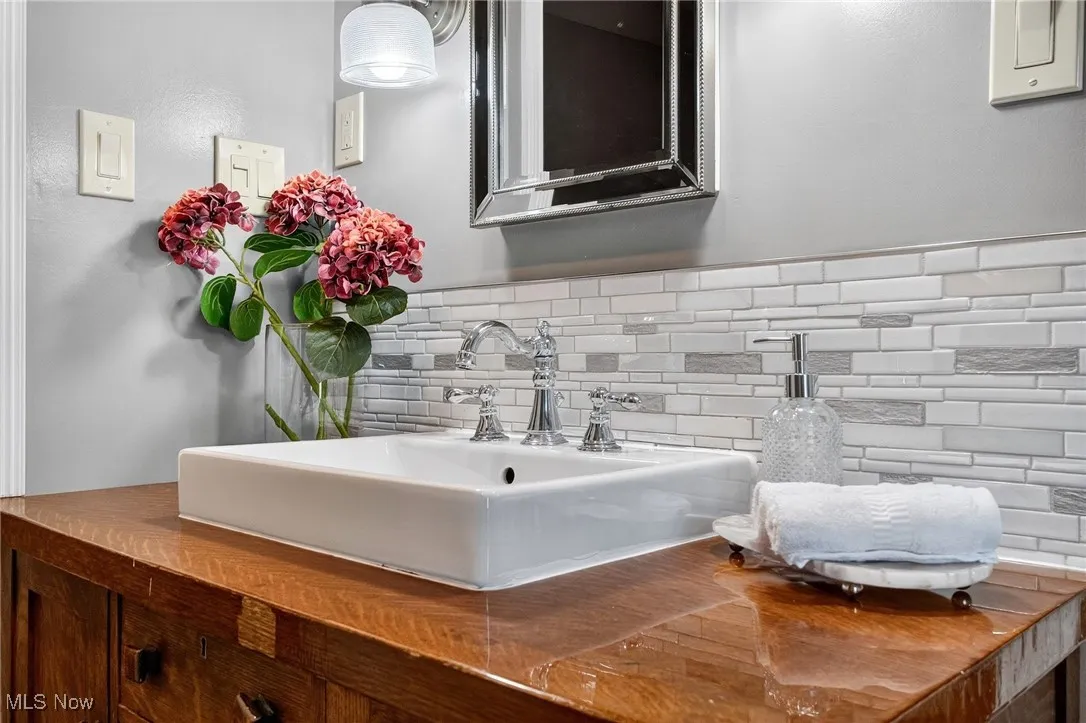 Bathroom featuring a sink and decorative backsplash