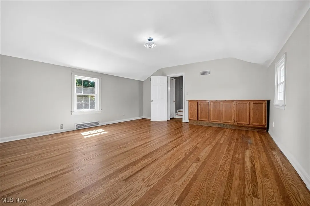 Additional living space with vaulted ceiling and light wood-type flooring