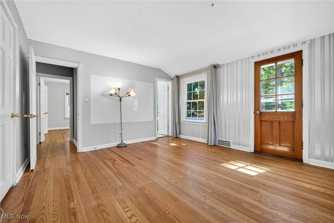 Unfurnished living room with light wood-style floors and lofted ceiling
