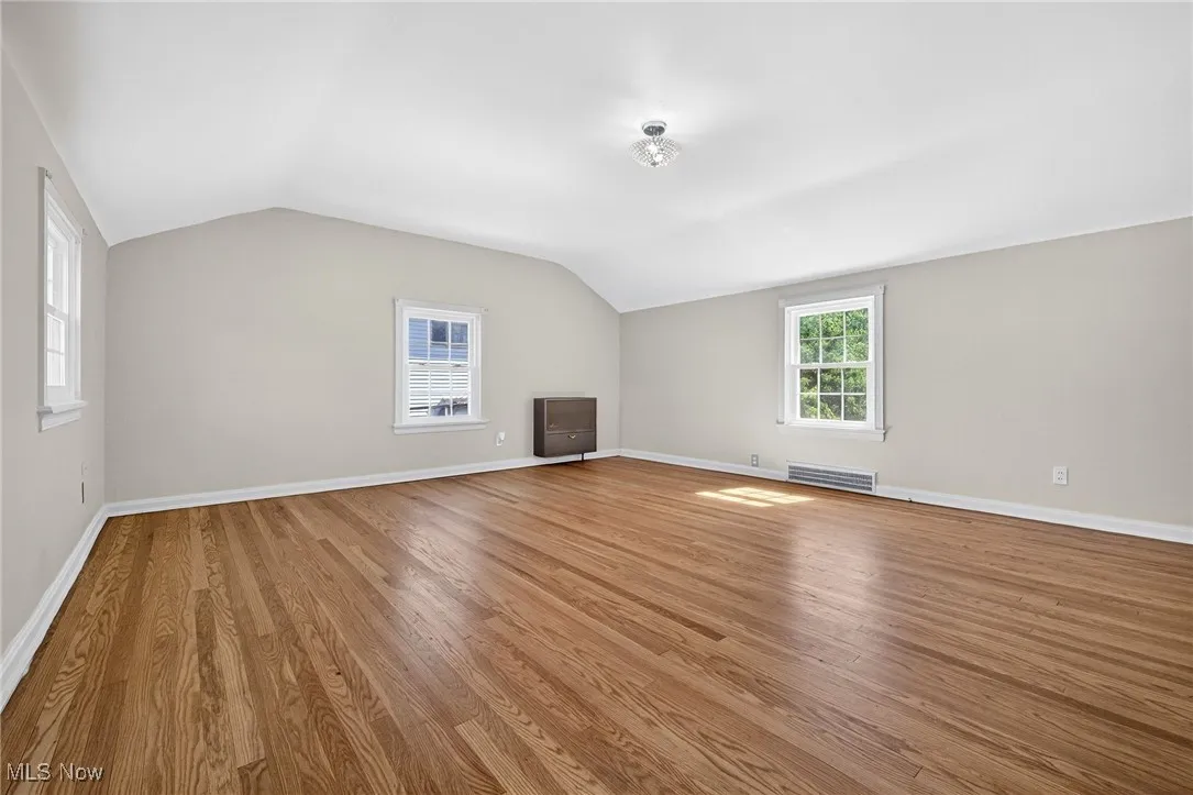 Bonus room with vaulted ceiling and light wood-style floors