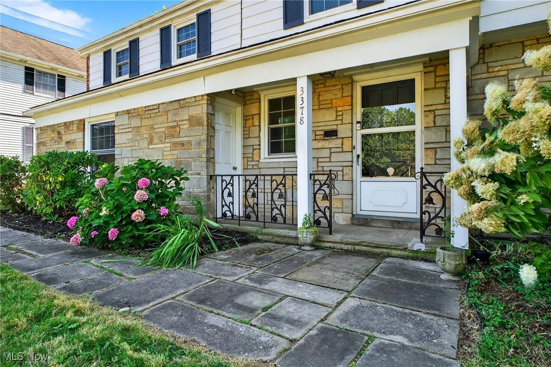 Entrance to property with stone siding and a porch