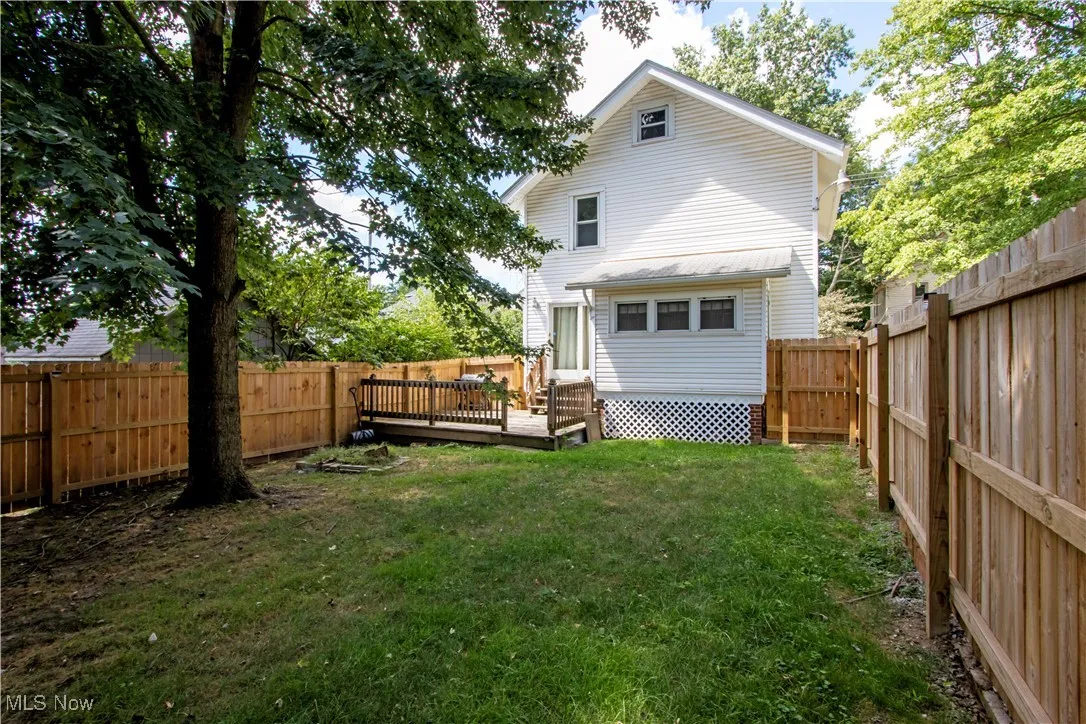 Rear view of property featuring a fenced backyard and a deck