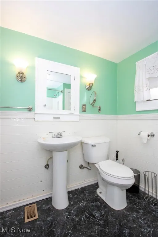 Bathroom with tile walls and wainscoting