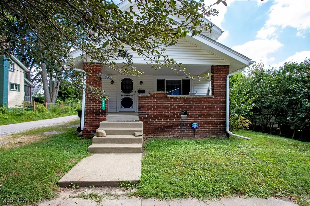 View of front of house with a front lawn and brick siding