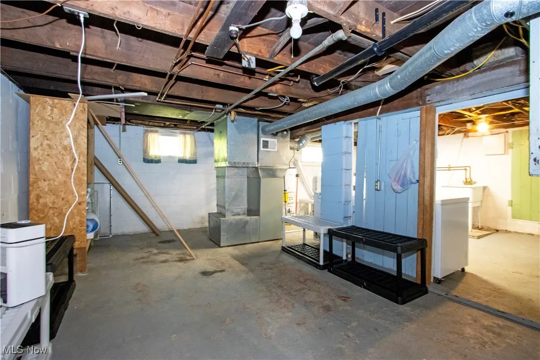 Basement with heating unit, gas water heater, and washer / clothes dryer