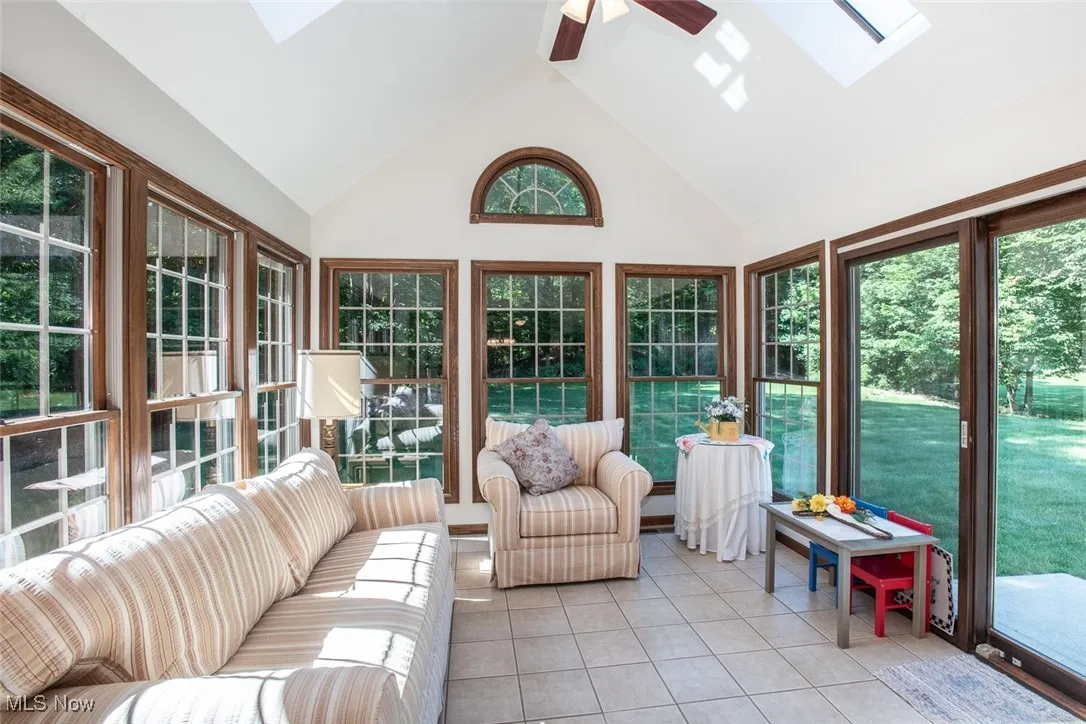 Sunroom with vaulted ceilings, skylights, and a fabulous view of the gorgeous trees on the property.