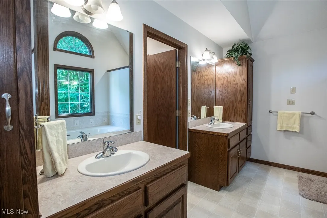 First floor owners adjoining bathroom dual sink and vanities for ample storage