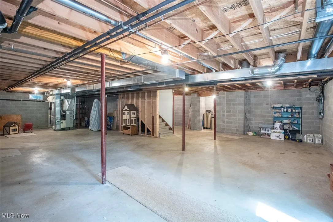 Large, tall open basement with two additional spaces on either side for storage.
