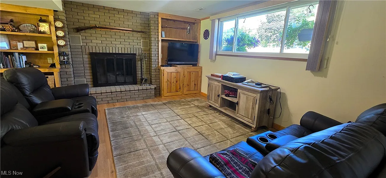 1st floor family room featuring a brick fireplace and build-in bookcases
