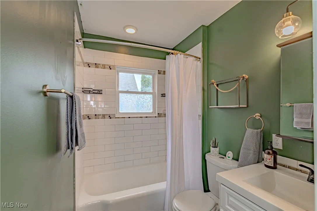 Full bath featuring shower / bath combination with curtain and vanity