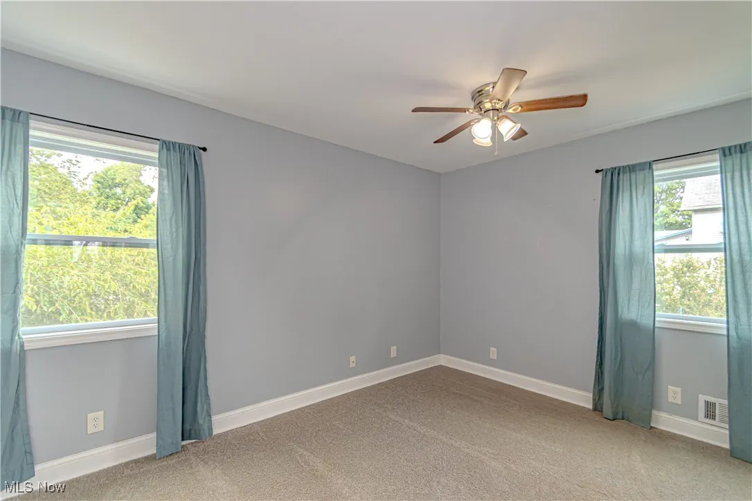 Unfurnished room with carpet and a ceiling fan