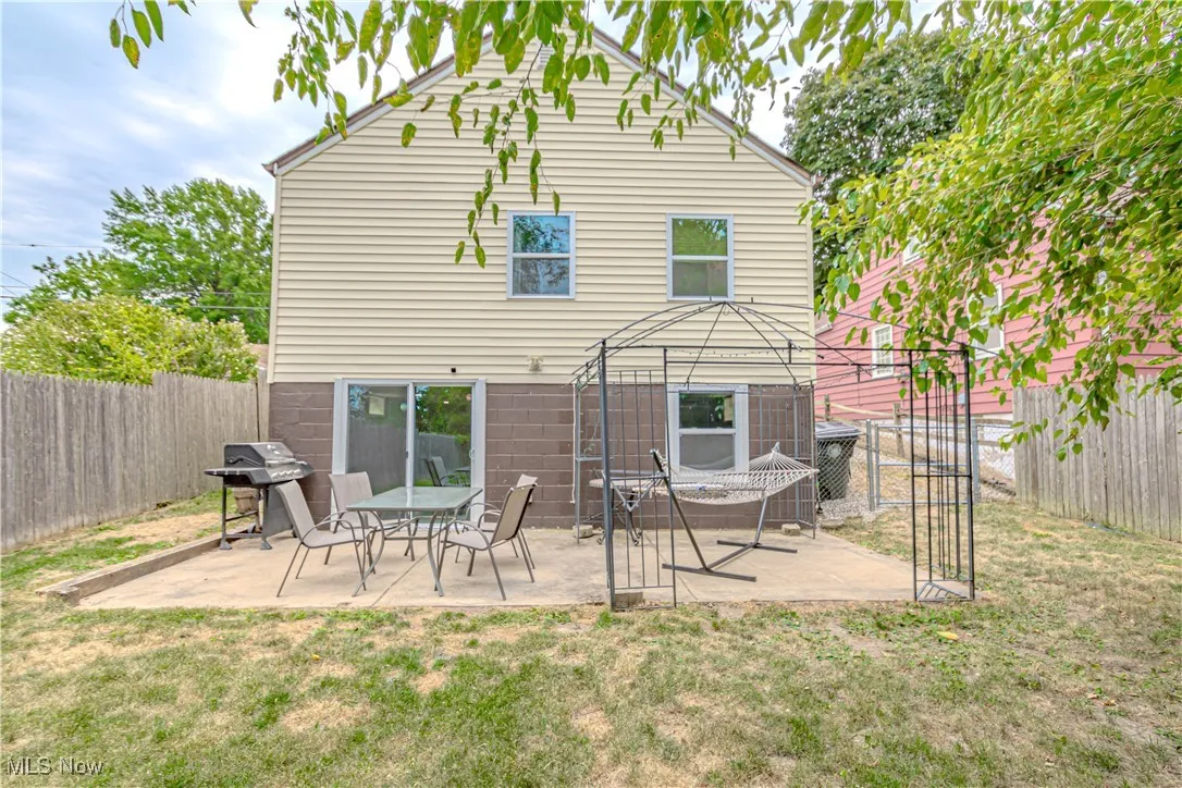 Rear view of property featuring a fenced backyard and a patio