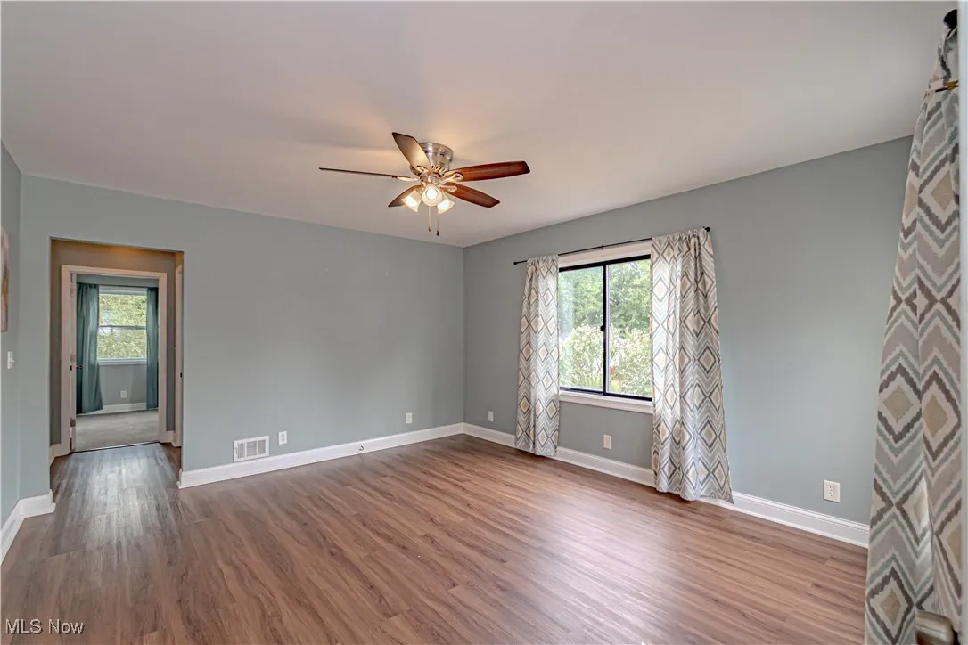 Unfurnished room with wood finished floors and a ceiling fan