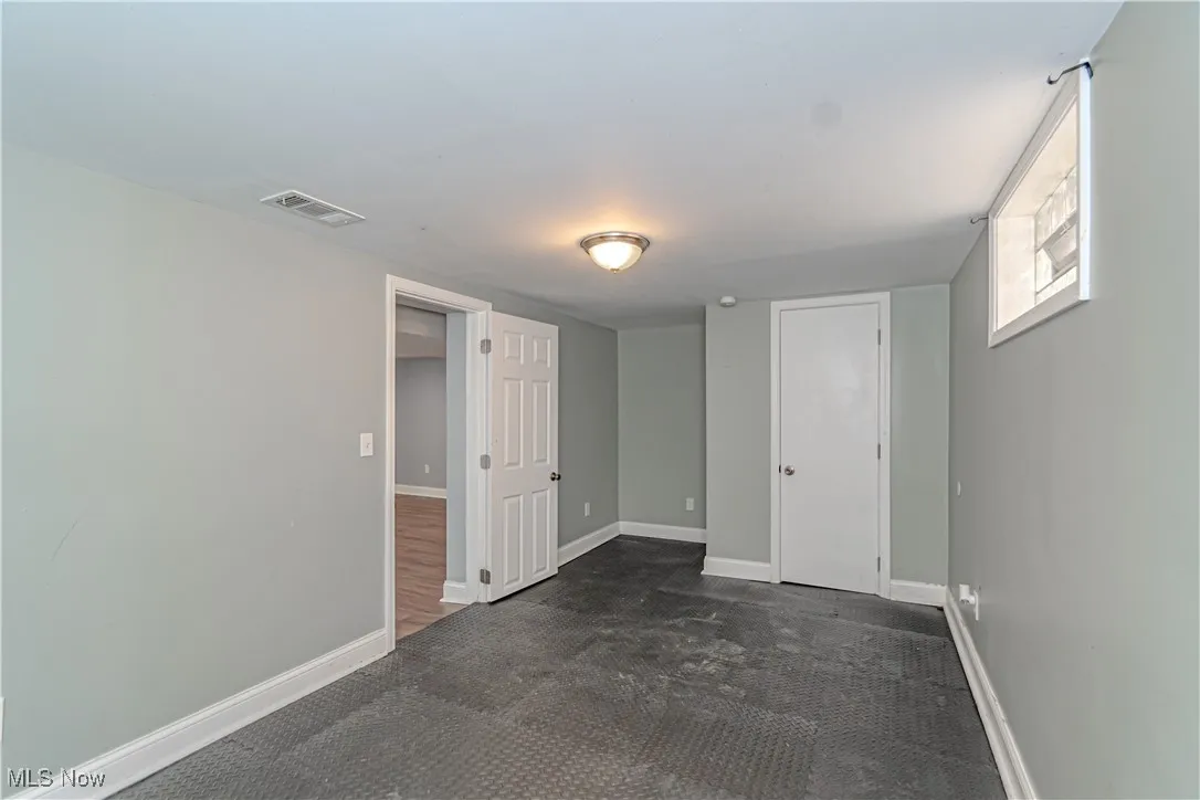 Below grade area with baseboards and dark carpet