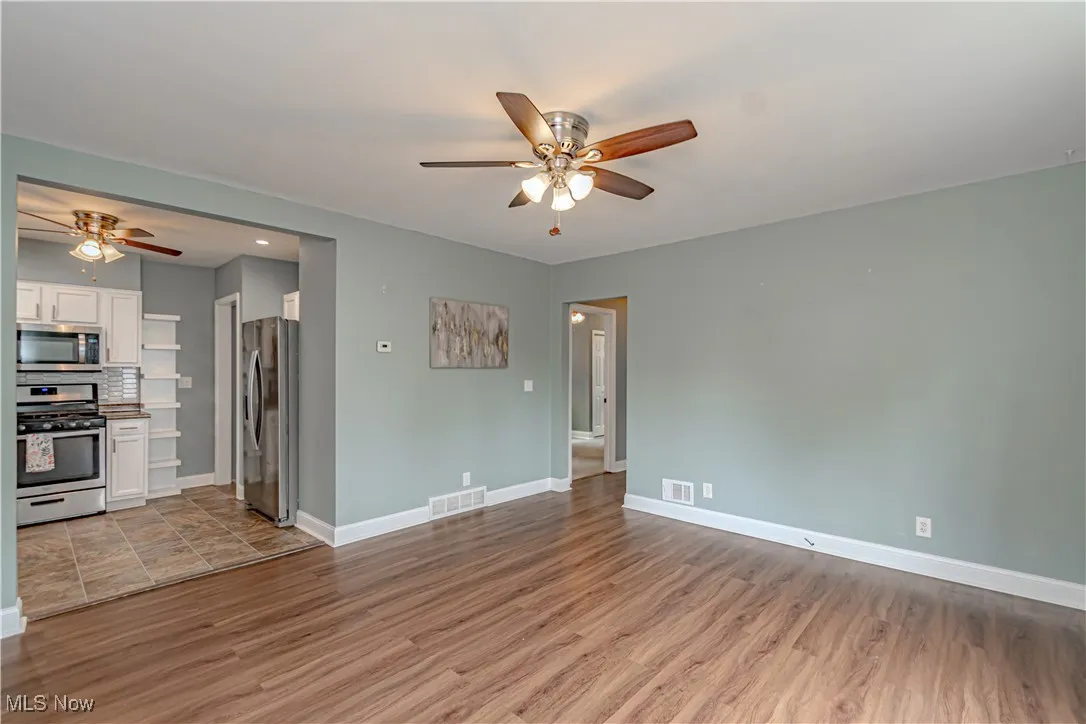 Unfurnished living room with ceiling fan and light wood-style floors