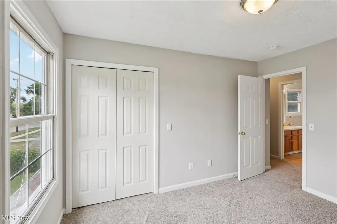 Unfurnished bedroom with light colored carpet and a closet