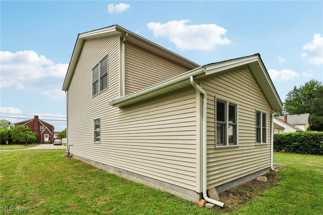 View of side of property featuring a yard