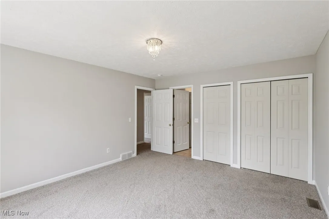 Unfurnished bedroom with a closet and light colored carpet