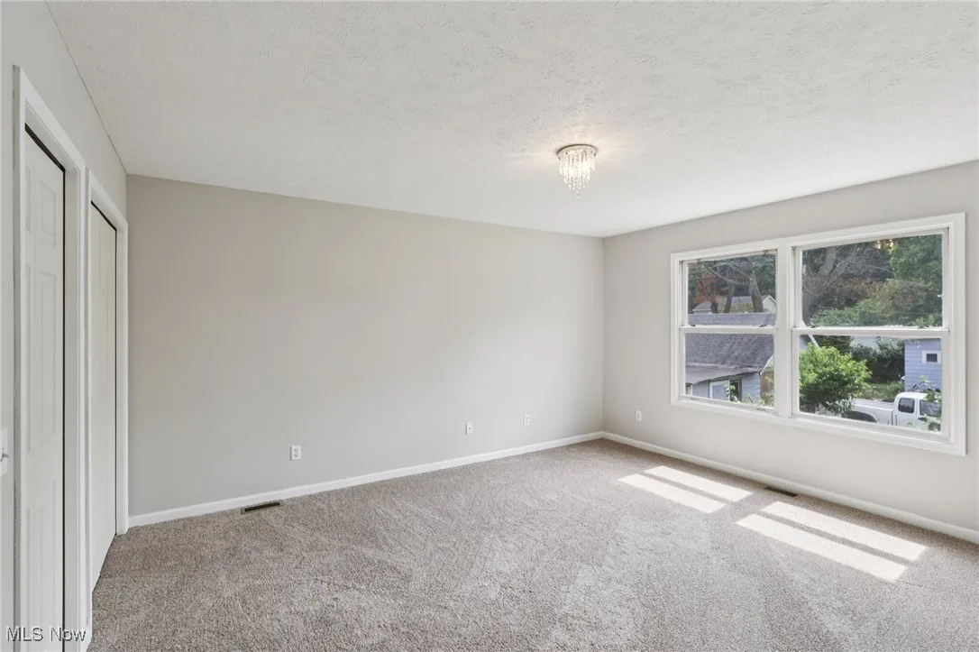 Unfurnished bedroom with carpet floors, a textured ceiling, and a closet